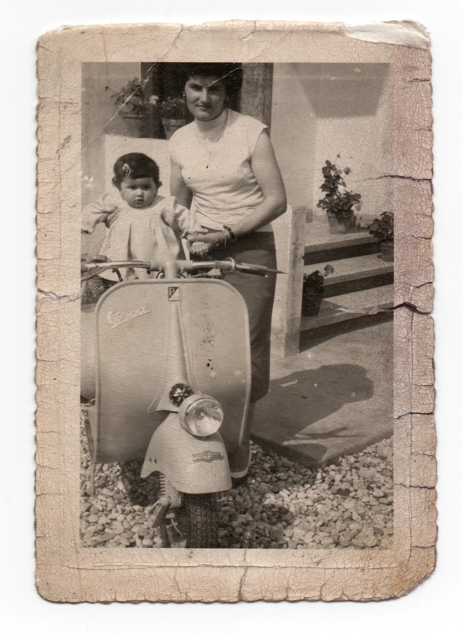 A woman and a small child beside a scooter, a black-and-white print