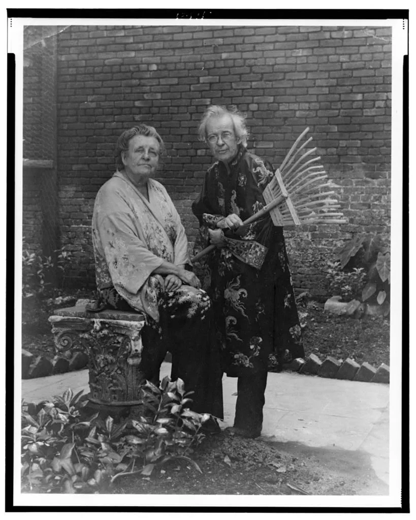 Frances Benjamin Johnston and "Pops" Whitesell in a New Orleans garden, before restoration — the gelatin silver print marked by dust and speckling, its sheet torn along the right edge